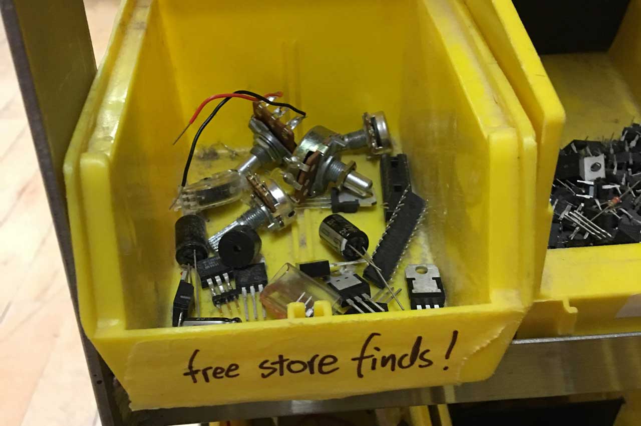 A bin in the shop labelled 'Free Store Finds' filled with components